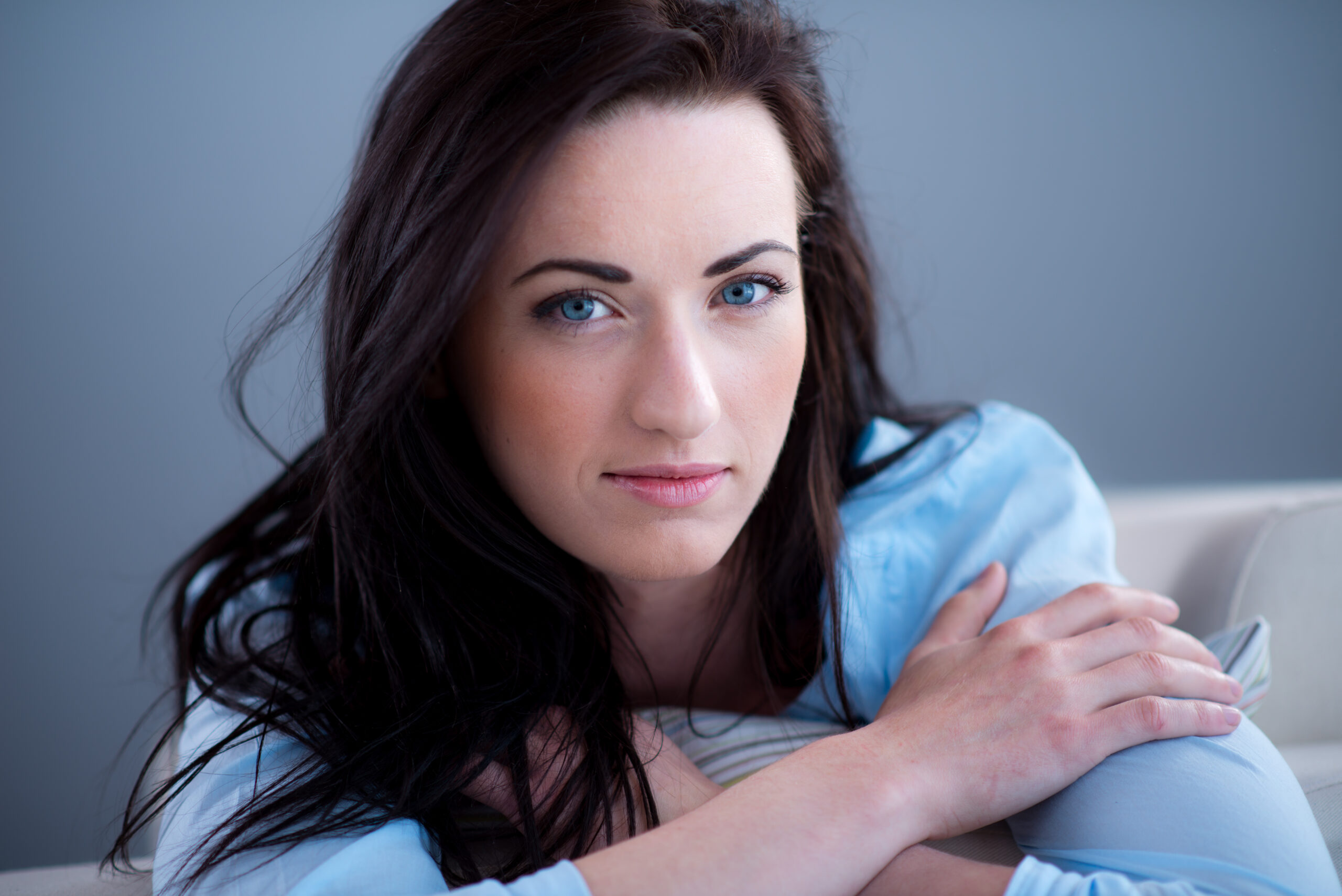 cheerful young brunette lying on her sofa relaxed at home